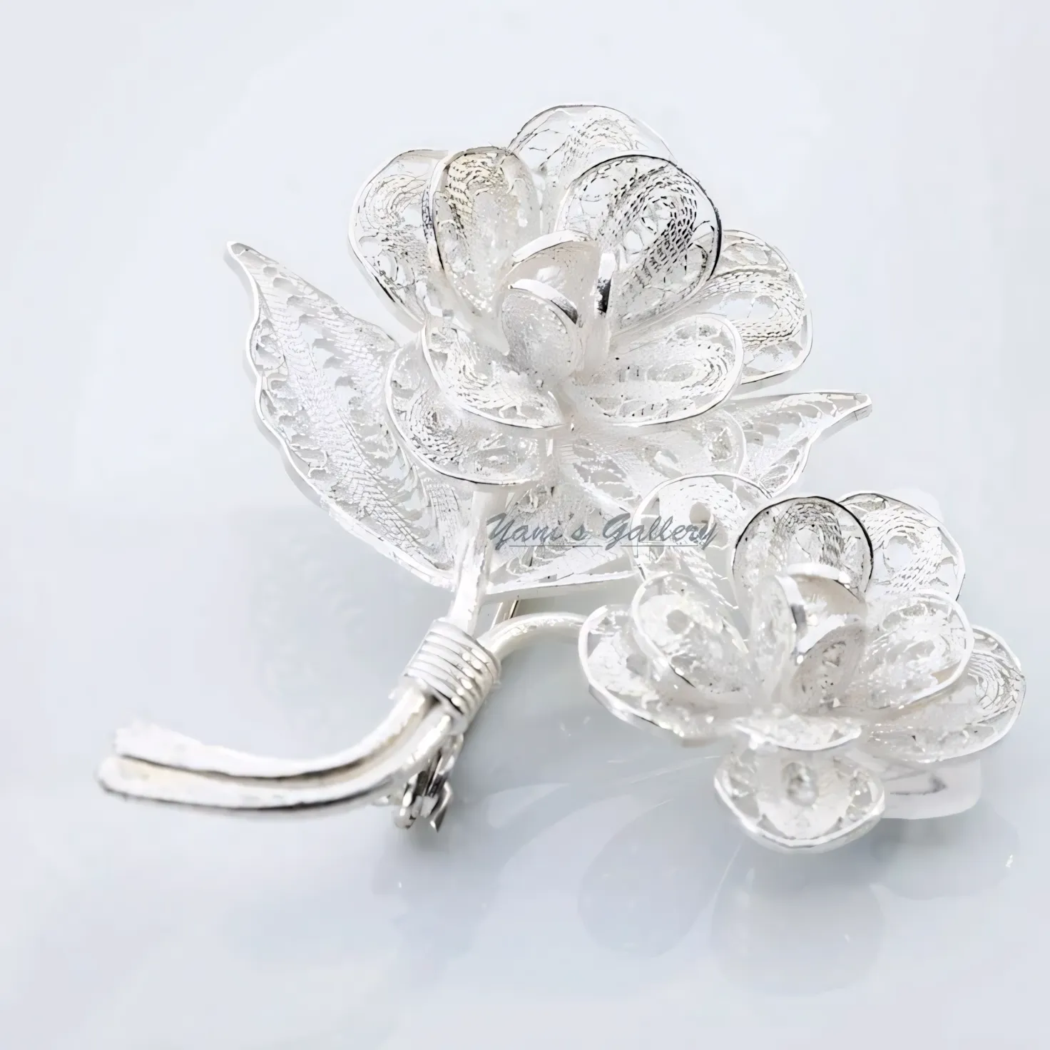 A silver brooch shaped as a flowering branch.