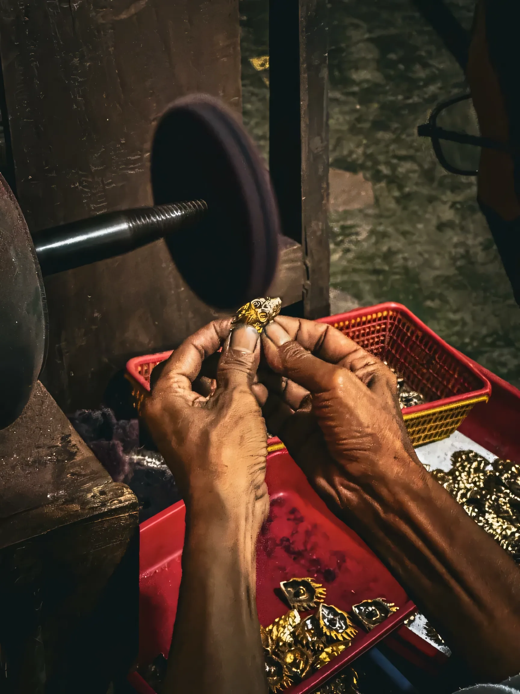 A jeweller's hands shaping a small piece of jewellery.
