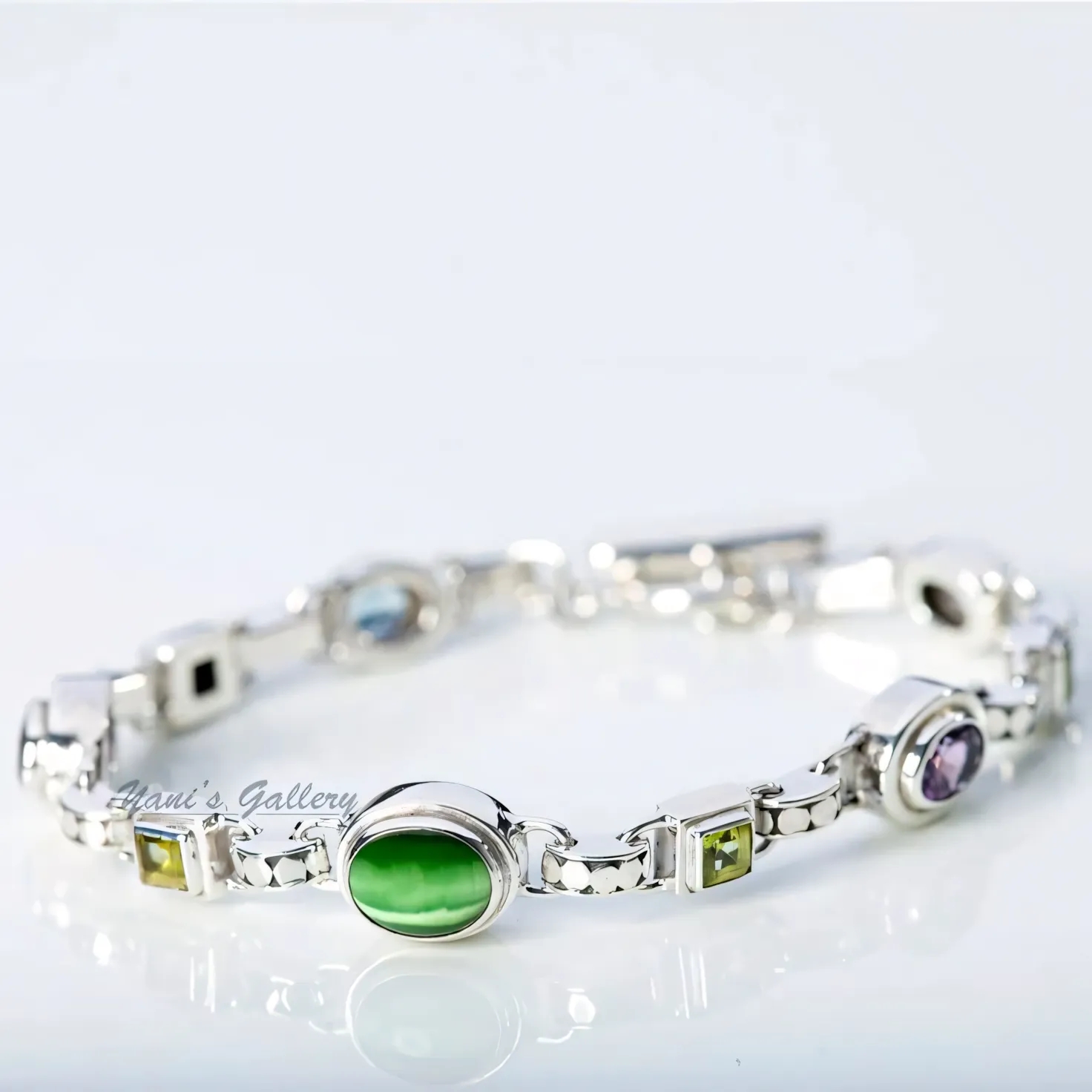 A silver bracelet set with coloured stones.